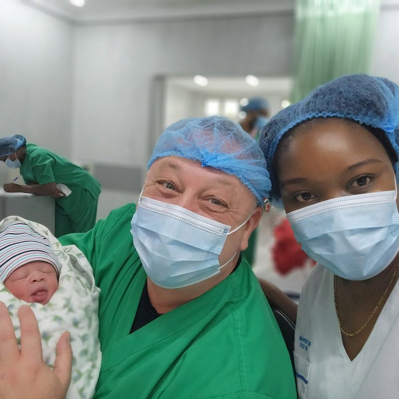 Theatre team with a newborn baby moments after delivery